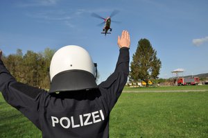 Policeman guiding the Rega rescue helicopter at the accident site