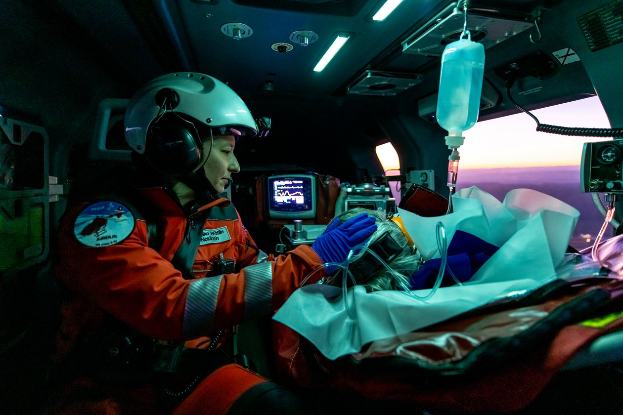 An emergency doctor treats a patient in the helicopter.