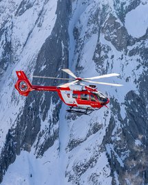 Rescue helicopter in flight in the mountains in winter