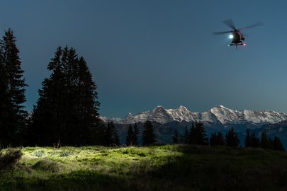 Suchhelikopter vor Gebirge bei Nacht