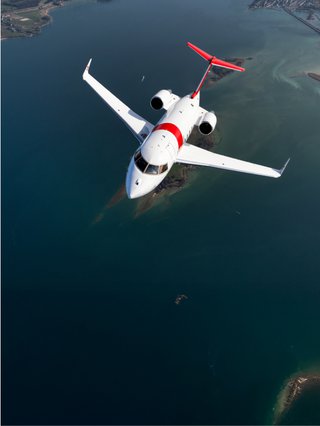 A Rega ambulance jet flies over the open sea.