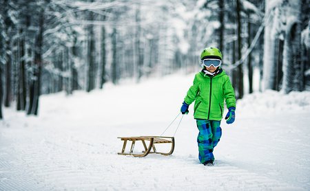 Kind mit Schlitten im Schnee