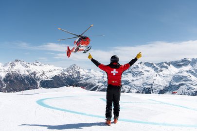 Ein Pistenretter weist den Rega-Helikopter auf der Skipiste ein