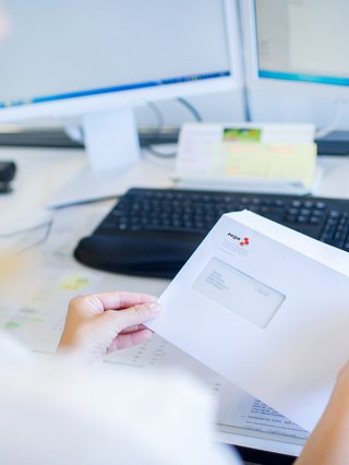 Person mit Rega-Brief in der Hand