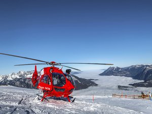 Rega-Helikopter steht auf dem Schnee, im Hintergrund Nebelmeer