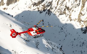 Rettungshelikopter H145 D3 der Rega über Schneebergen