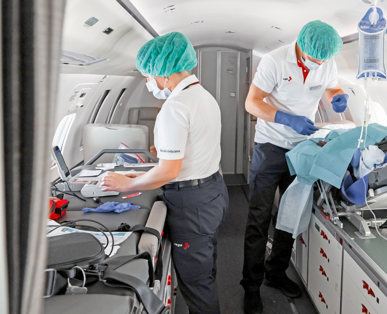 Ein Rega-Flugarzt führt einen kleinen Eingriff im Inneren eines Ambulanzjets durch.