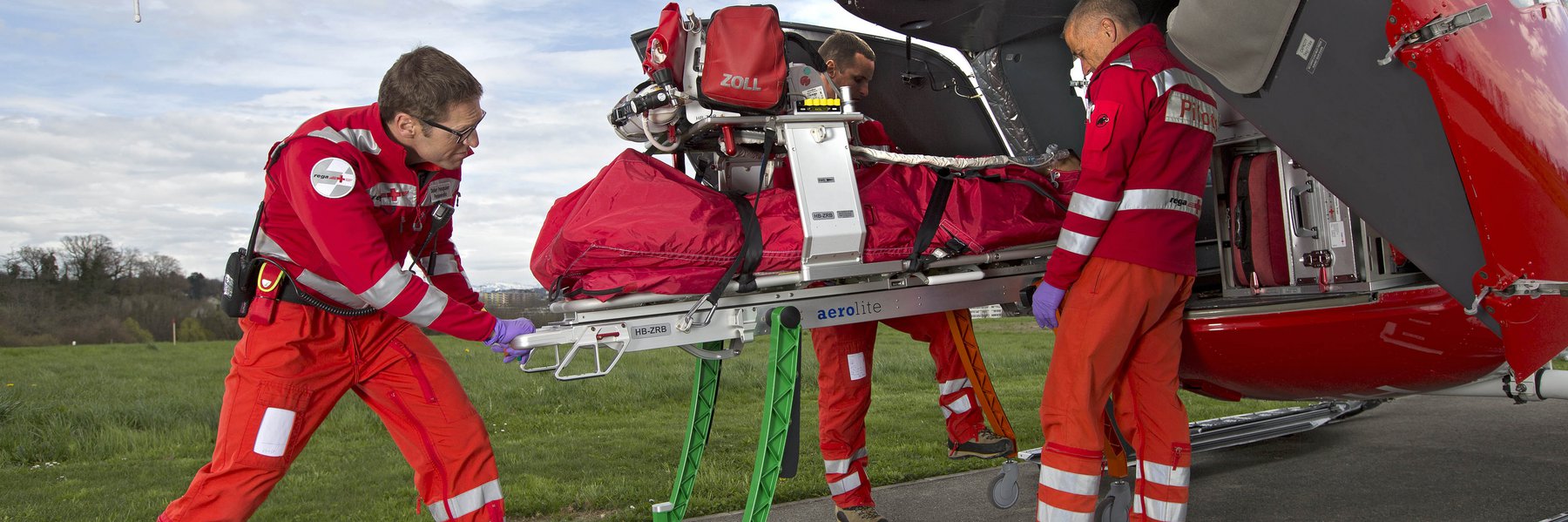 L'équipage Rega charge la nouvelle civière Roll-in dans l'hélicoptère EC 145.