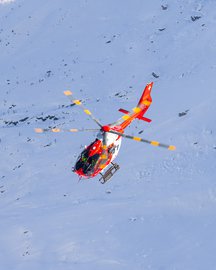 Rescue helicopter flying over a winter landscape