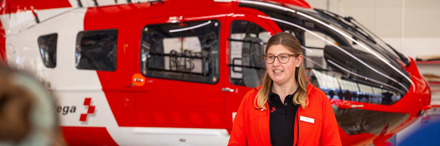 Referentin bei einer Führung vor einem Rettungshelikopter