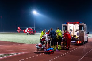 Ambulanzfahrzeug neben Rettungshelikopter