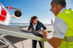 Daniela Bergamin, pilota di jet, assiste nell'apertura della rampa sviluppata appositamente per la Rega, che consente di caricare i pazienti sdraiati nel jet. È visibile anche un operatore a terra.