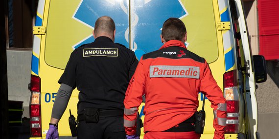Ambulanciers de la Rega et de l'ambulance devant une ambulance