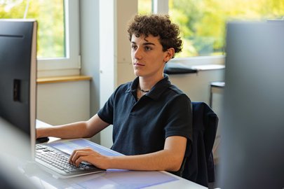 Kaufmann arbeitet am Computer