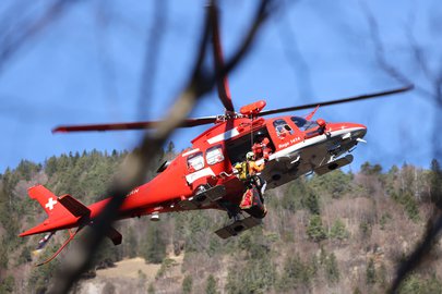 Rettungshelikopter Da Vinci in der Luft mit Bergretter der Alpinen Rettung Schweiz 