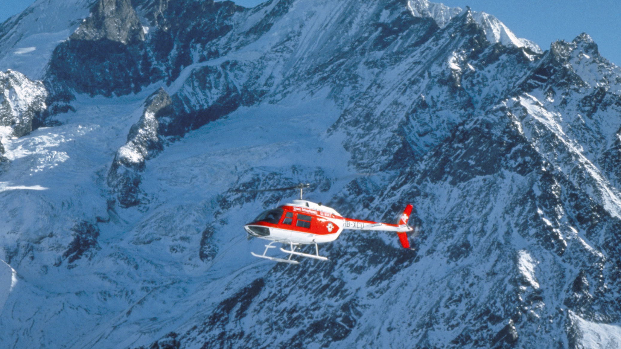 Elicottero rosso Bell 206A Jet Ranger in un ambiente innevato.